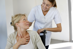 Nurse at home with elderly person in wheelchair