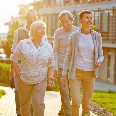 Happy senior travel group walking in a city in summer